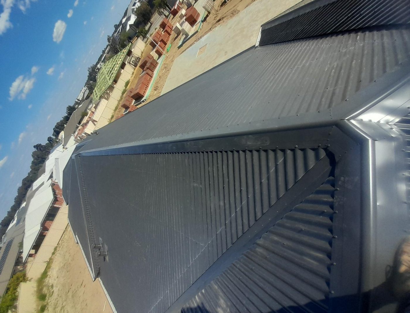 Finished corrugated sheeting, hips and ridge capping on a new-build roof